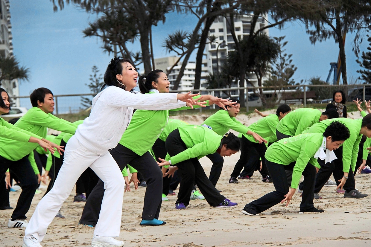 Bai (in white) teaching students the right qigong pose during a lesson.