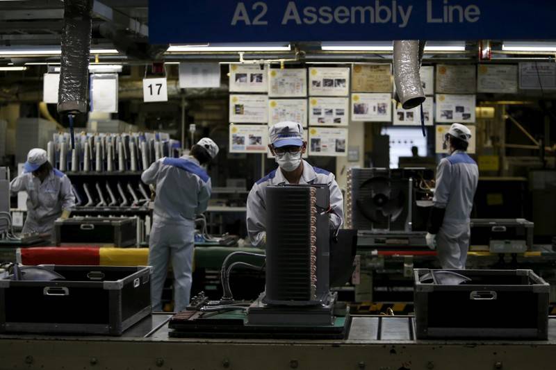 FILE PHOTO Daikin Industries Ltd employees work the production line of outdoor air conditioning units at the companys Kusatsu factory in Shiga prefecture western Japan March 20 2015. REUTERSYuya ShinoFile Photo
