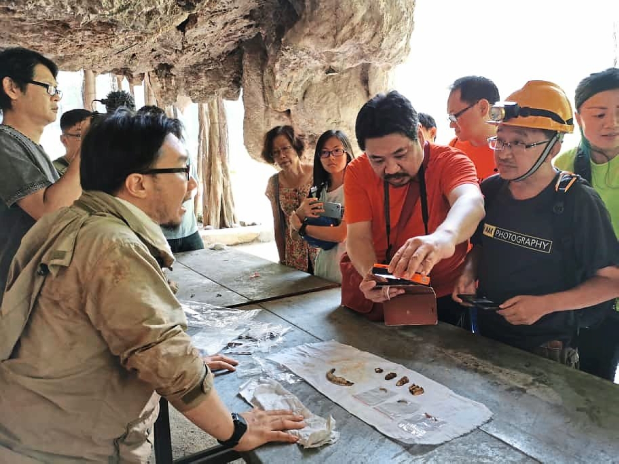 Participants having a closer look at some fossilised bones found by caving enthusiasts in Gunung Rapat, Ipoh.