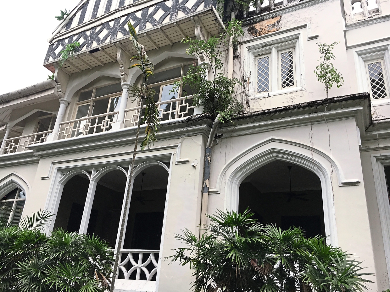 Overgrown plants and vines are slowly claiming the facade of Carcosa.