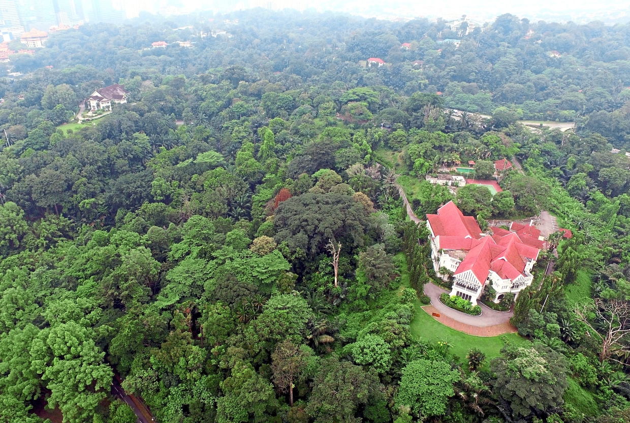 Carcosa with its pink roof looks grand from above surrounded by lush greenery. To the far left is the Seri Negara building.