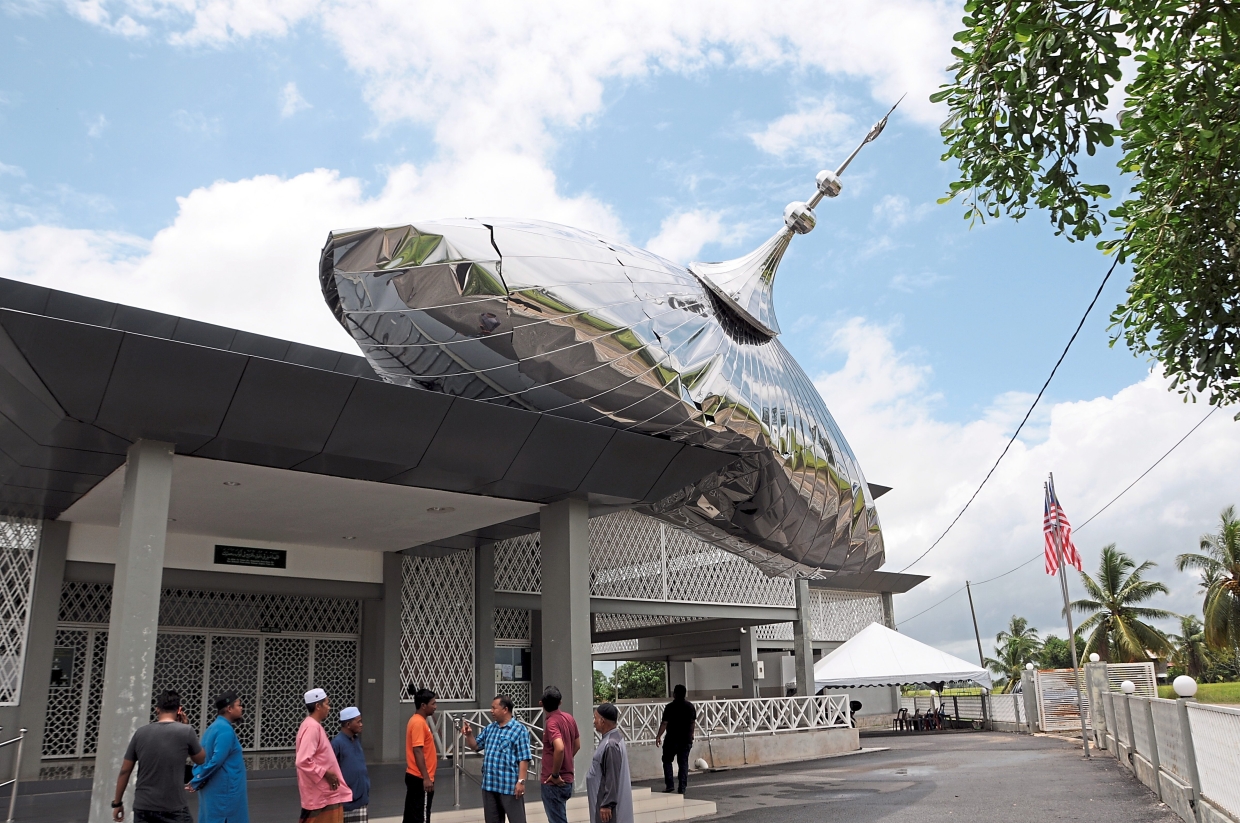 Tunjang mosque committee members and villagers discussing the next cause of action after the storm damaged the dome and part of the roofing at the mosque in Jitra, Kedah.