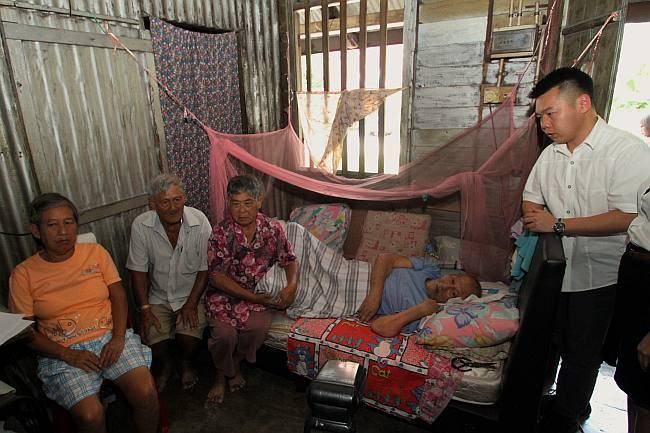 MCA Perak complaint bureau chief Low Guo Nan (3rd from right) talk with the elderly siblings who need assistance help at their home at Falim.