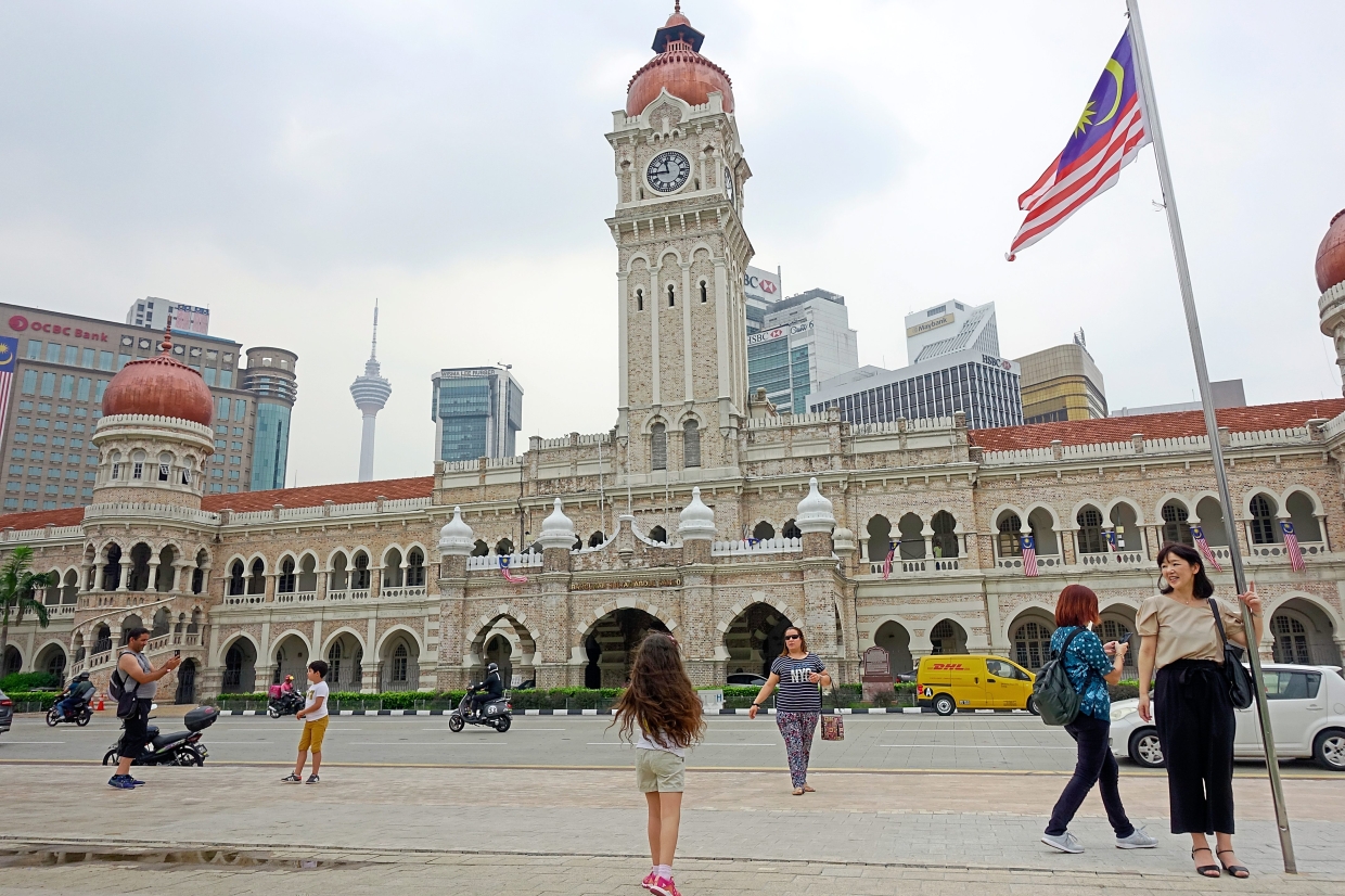 Historical monument: Visitors posing with the clock and Sultan Abdul Samad building in the background.  —Bernama