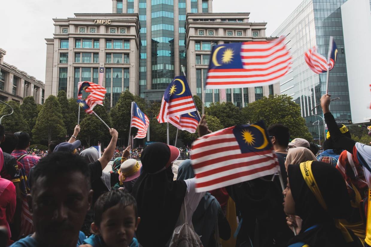 People waving the Jalur Gemilang flag in Putrajaya.