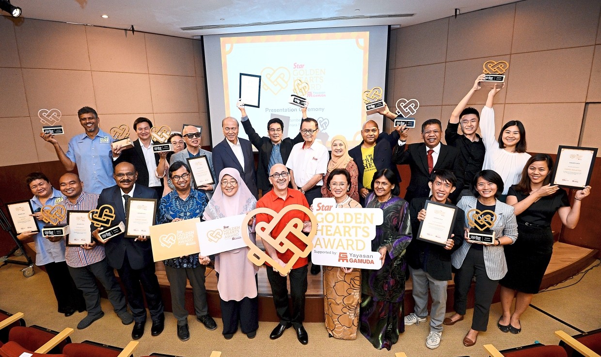 Worthy recipients: The top 10 winners of Star Golden Hearts Award together with chief judge Lee (back row, fifth from left) and fellow panel judges posing after the awards presentation ceremony at Menara Star. With them are Star Media Group Bhd chairman Fu (back row, middle) and chief executive officer Andreas Vogiatzakis (in red).