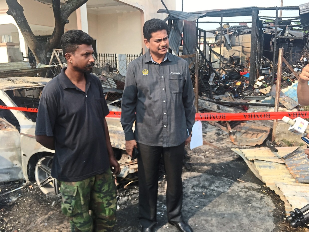 It’s all gone: Nineswaran (left) and Sivasubramaniam looking at the house that was razed in the fire.