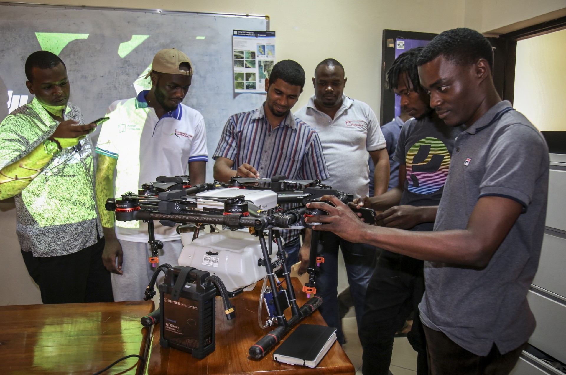 Trainee drone pilots from the State University of Zanzibar examine a drone to be used to spray the breeding grounds of malaria-carrying mosquitoes, at Cheju paddy farms in the southern Cheju region of the island of Zanzibar.