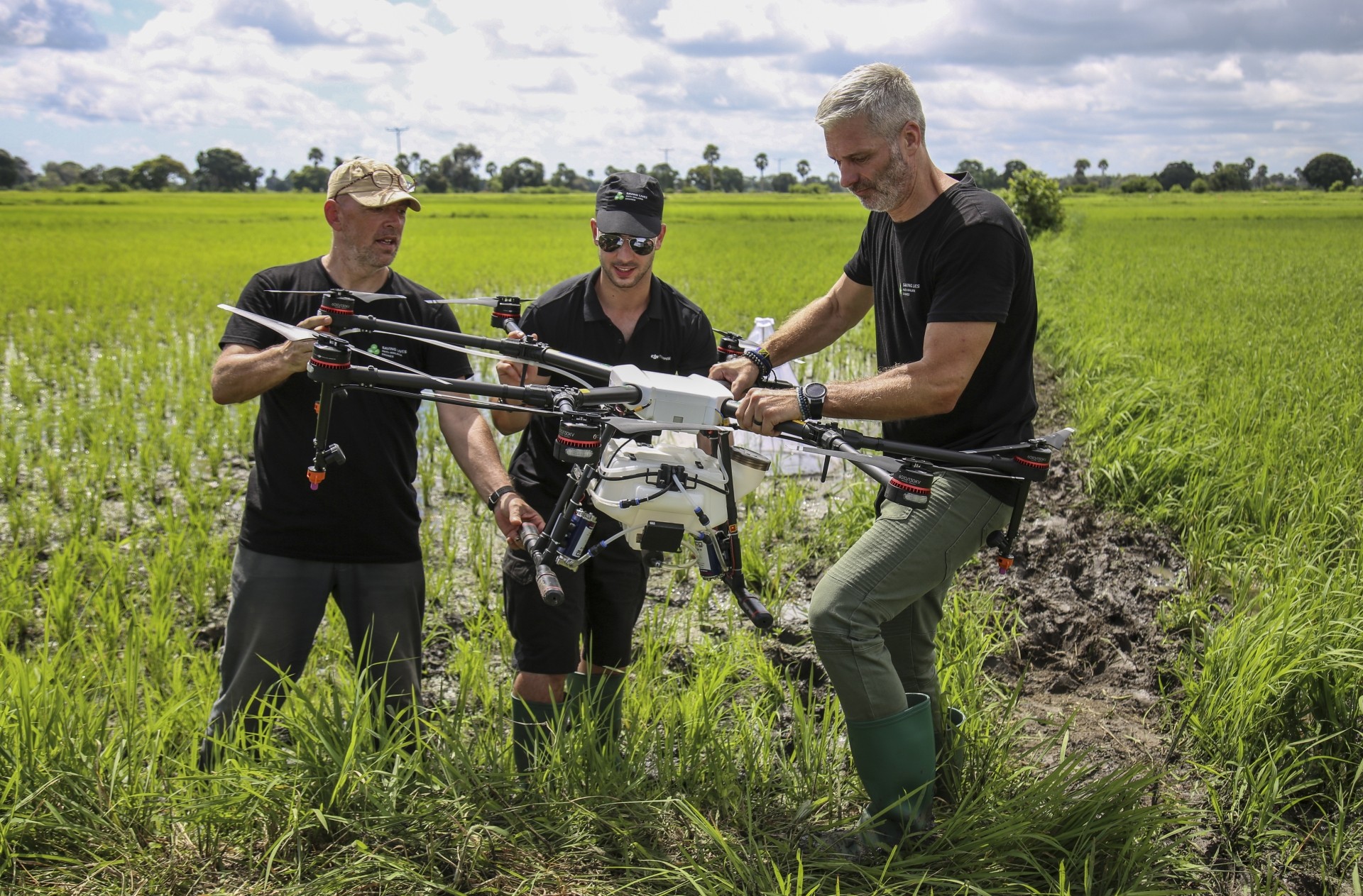 Knols (left), Rodriguez (centre) and Guido Welter, a consultant from the Anti-Malaria Drones programme, preparing a drone to spray the breeding grounds of malaria-carrying mosquitoes, at Cheju paddy farms.