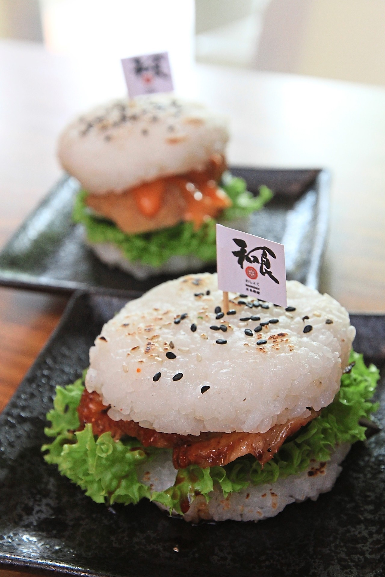 Unagi Sushi Burger (front) and Hot and Spicy Tori Karaage Sushi Burger use sushi rice patties as the burger bun.