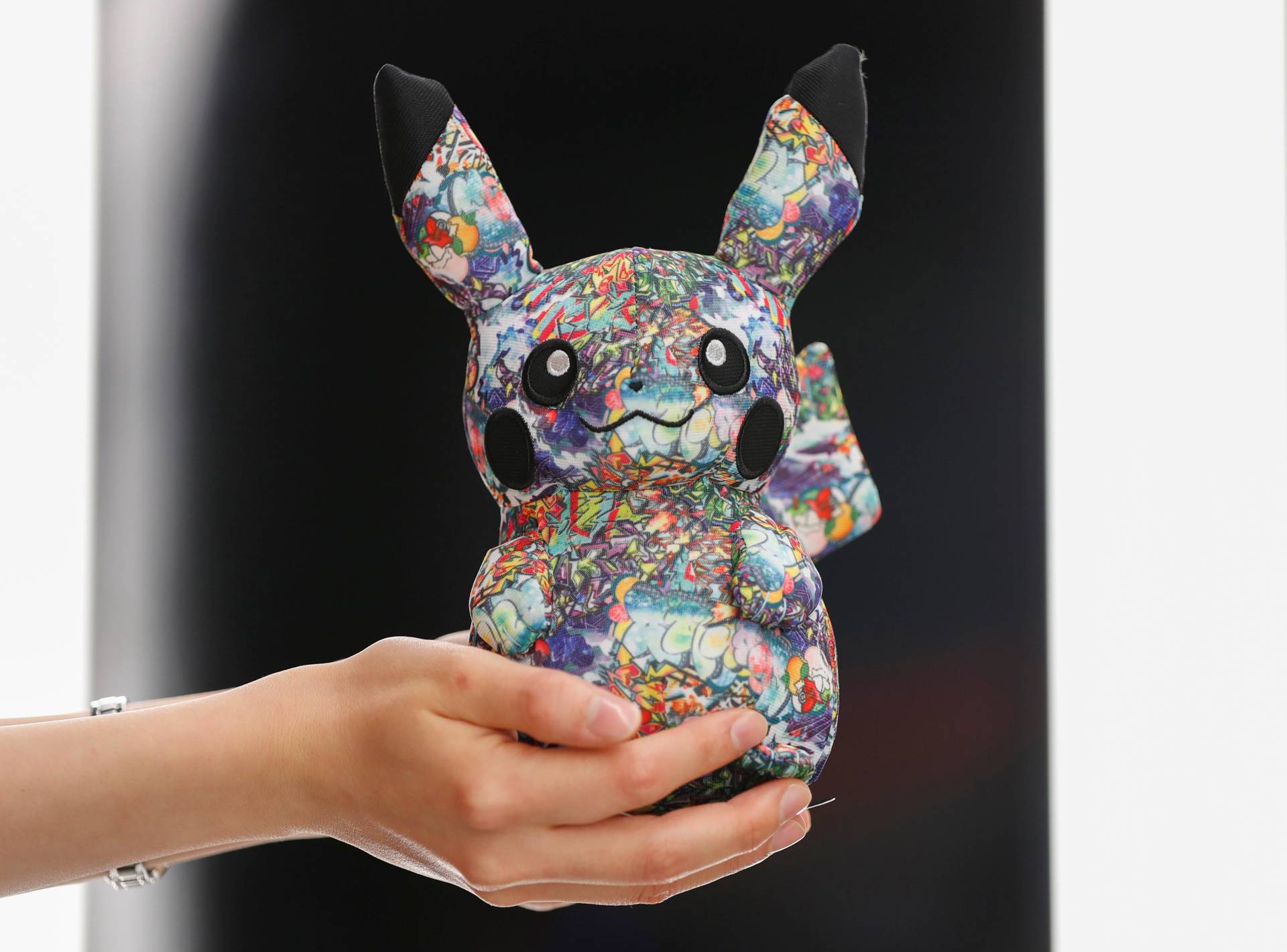 A sales personnel showing off a limited edition graffiti version Pikachu at Pokemon Center Shibuya. — Reuters