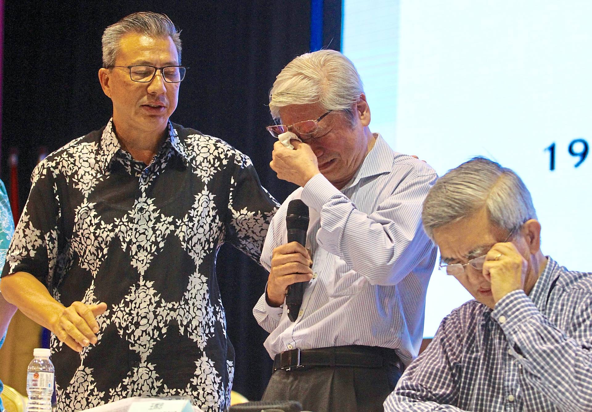 Emotional issue: Liow (left) consoling Lau Yin Pin and his secretary Ong Whee Tiong during a special briefing on the latest situation on TAR UC.