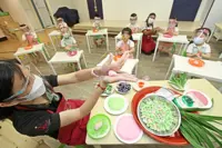 Kids elbow deep   in tang yuan tradition