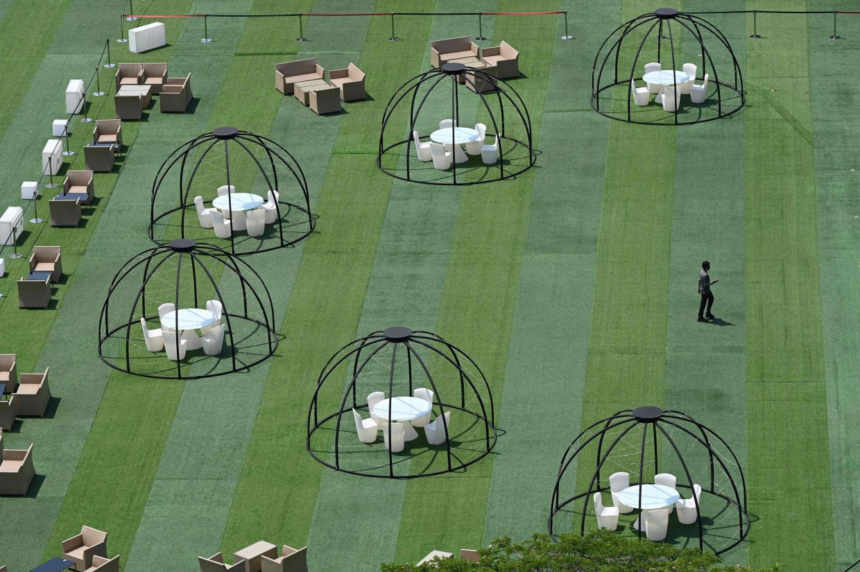 A worker prepares an outdoor restaurant on Sentosa Island in Singapore. - AFP