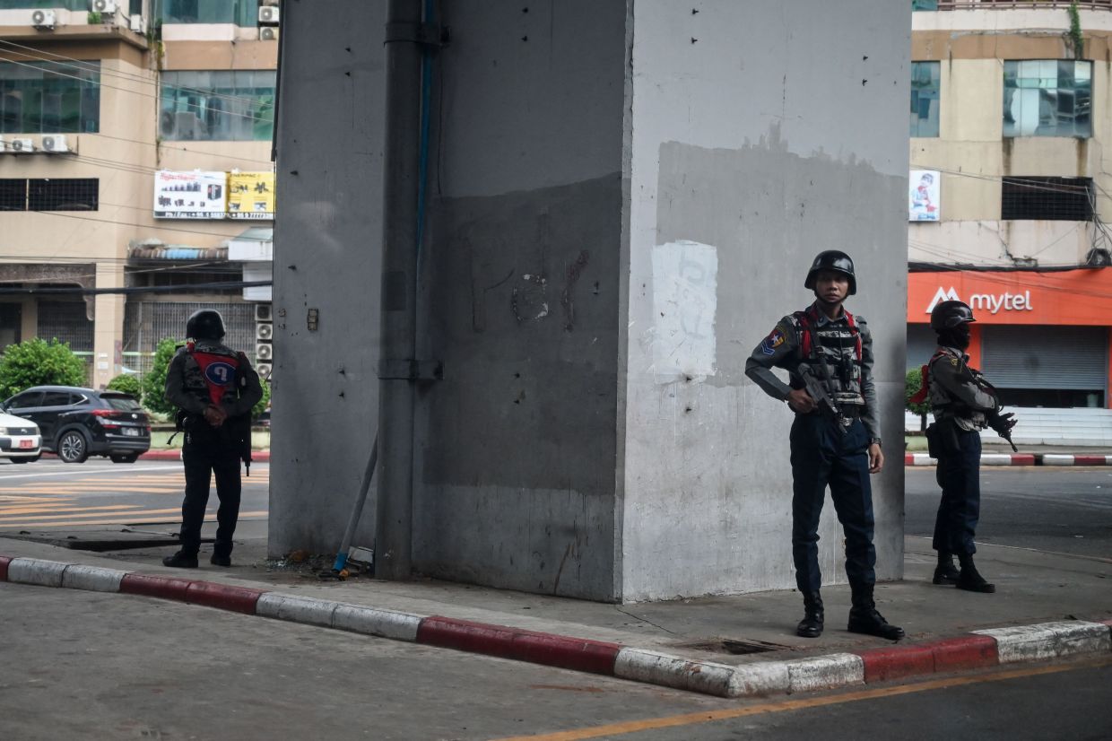 Members of the Myanmar security forces stand guard on a street in Yangon on July 19, 2022, on the 75th Martyrs' Day that marks the anniversary of the assassination of independence leaders including general Aung San, father of the currently deposed and imprisoned leader Aung San Suu Kyi. - AFP