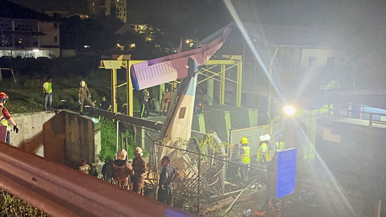 Tragic end: Rescuers at the scene of the crash site at Jalan Dr Nazrin Shah, Ipoh.