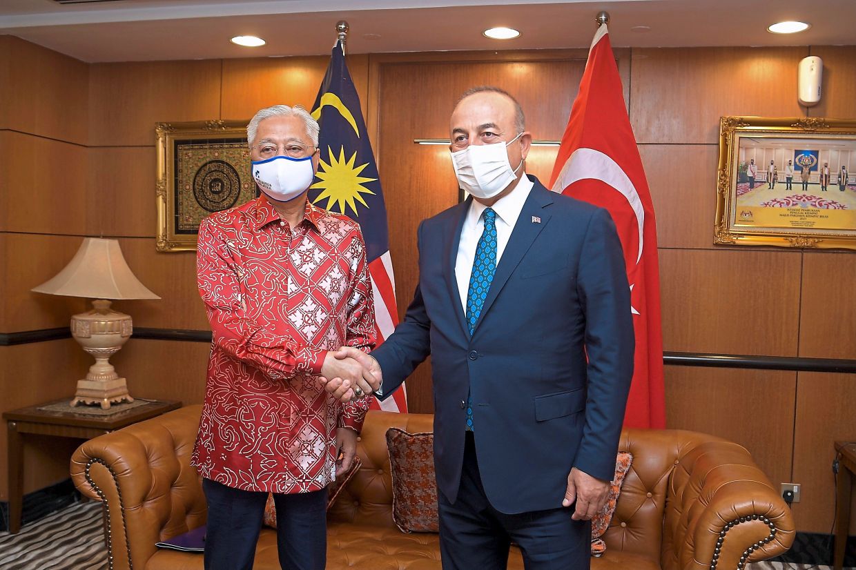 Courtesy call: Ismail Sabri and Cavusoglu shaking hands at Parliament House in Kuala Lumpur. — Bernama