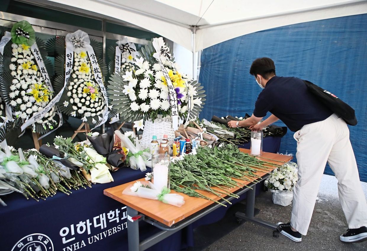 A student paying tribute to a victim who was murdered at Inha University recently.  – The Korea Herald/Asia News Network