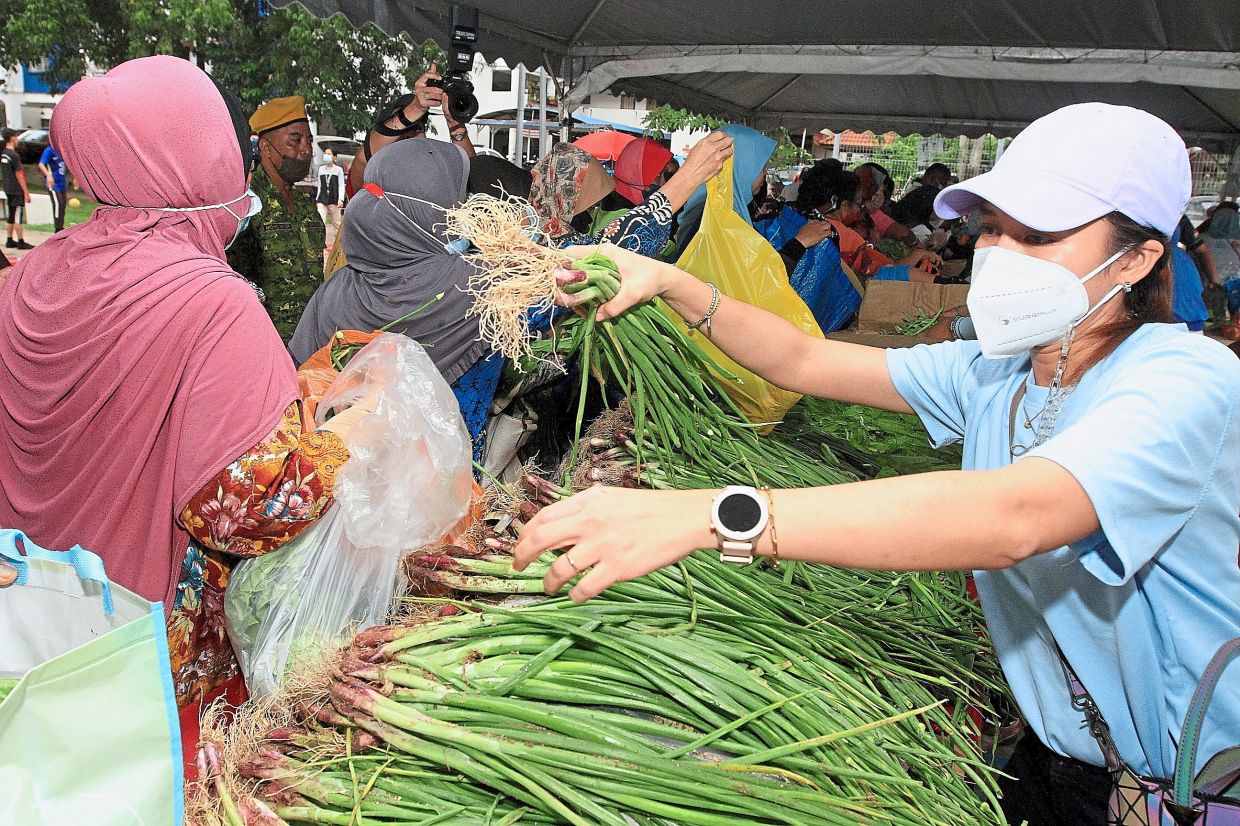 Volunteers helping to distribute fresh produce to the PPR Kerinchi residents. — Photos: SHAARI CHEMAT/The Star