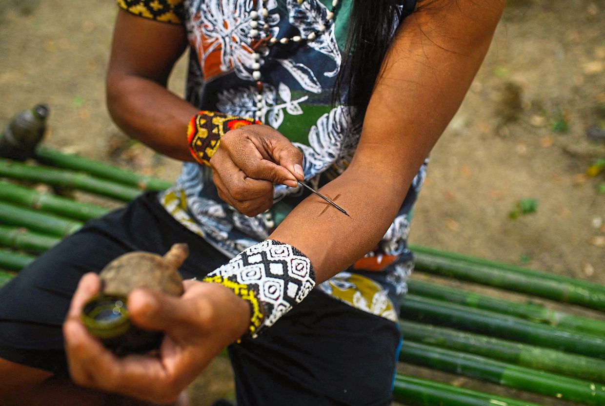 Weraxunu painting his arm at the Kyringue Arandua indigenous land.