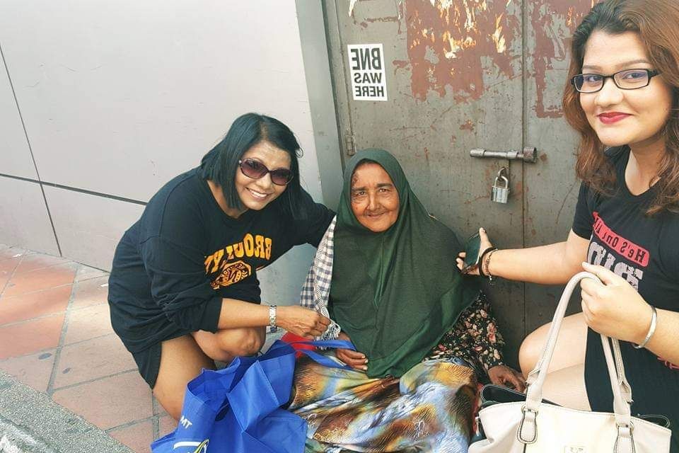 Pritam and educator Serene providing food, masks and sanitisers to the needy in Cheras.