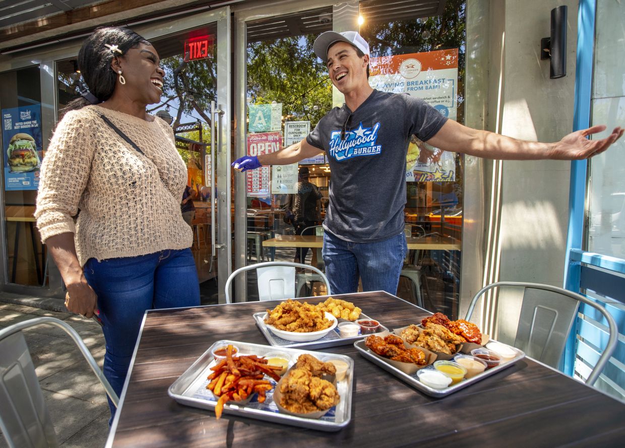 Nkechi Ahaiwe, a food influencer based in Los Angeles, is all smiles after having her food order delivered to an outdoor table. — Los Angeles Times/TNS