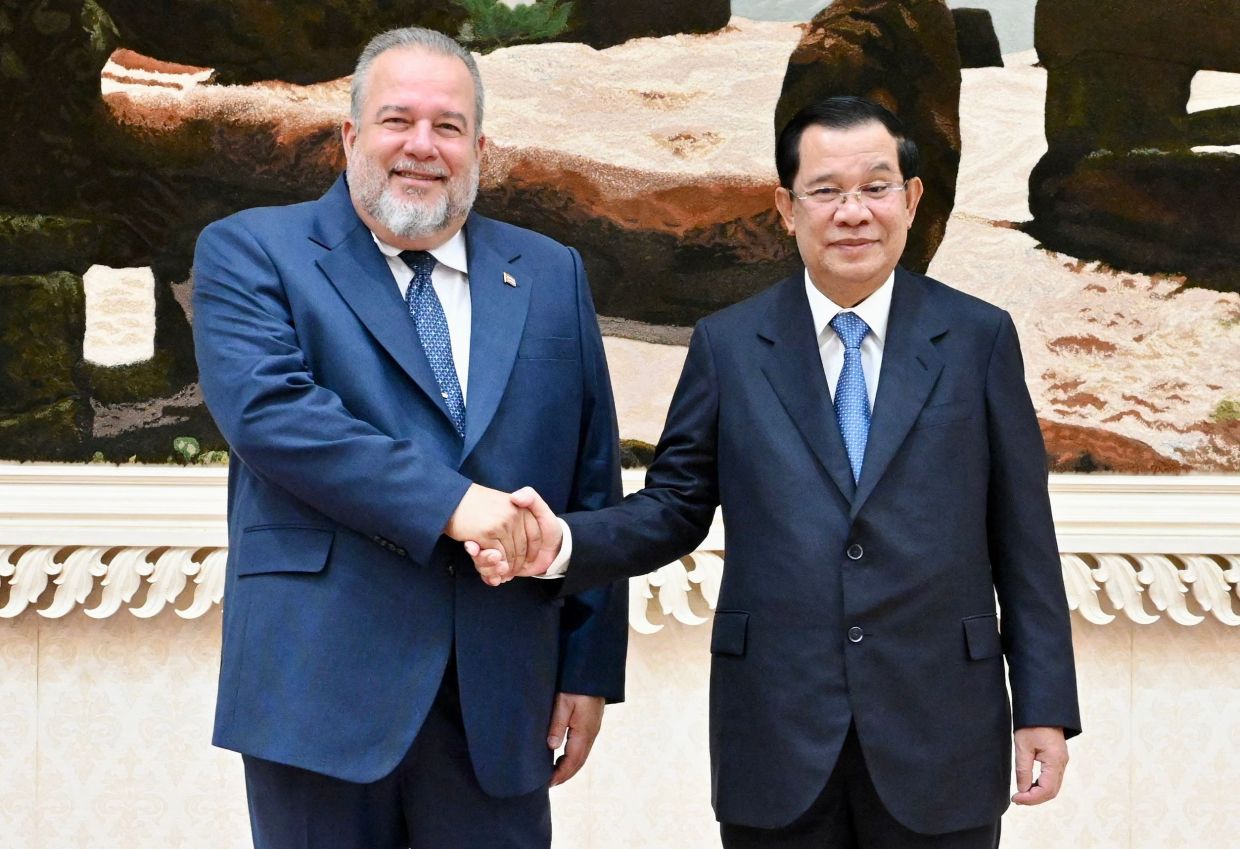 Cambodia's Prime Minister Hun Sen (right) and Cuba's Prime Minister Manuel Marrero shaking hands during a meeting at the Peace Palace in Phnom Penh on Tuesday (Oct 4, 2022). - AFP 