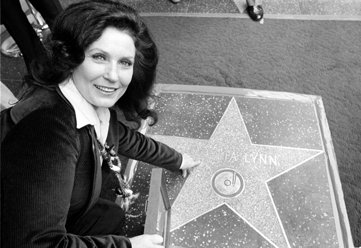 Country music singer Loretta Lynn points to her Hollywood Walk of Fame star during induction ceremonies in Hollywood, Calif., on Feb. 8, 1978. – AP