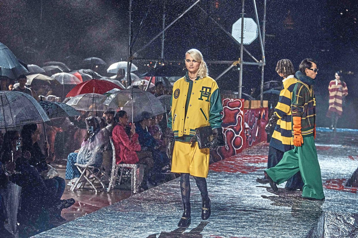 Caught by surprise: guests under the rain for the Tommy Hilfiger runway show. Photo: AFP