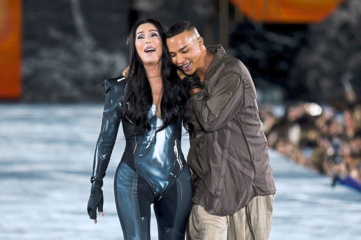 Cher walks next to Balmain creative director Olivier Rousteing. She presented a creation at the runway show in Paris. Photo: AFP