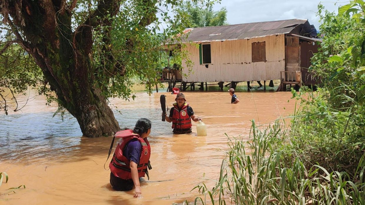 Fire and Rescue Department personnel tending to the call about four individuals trapped in a house in Jalan Ramayah, Penampang. - Pic courtesy from Bomba