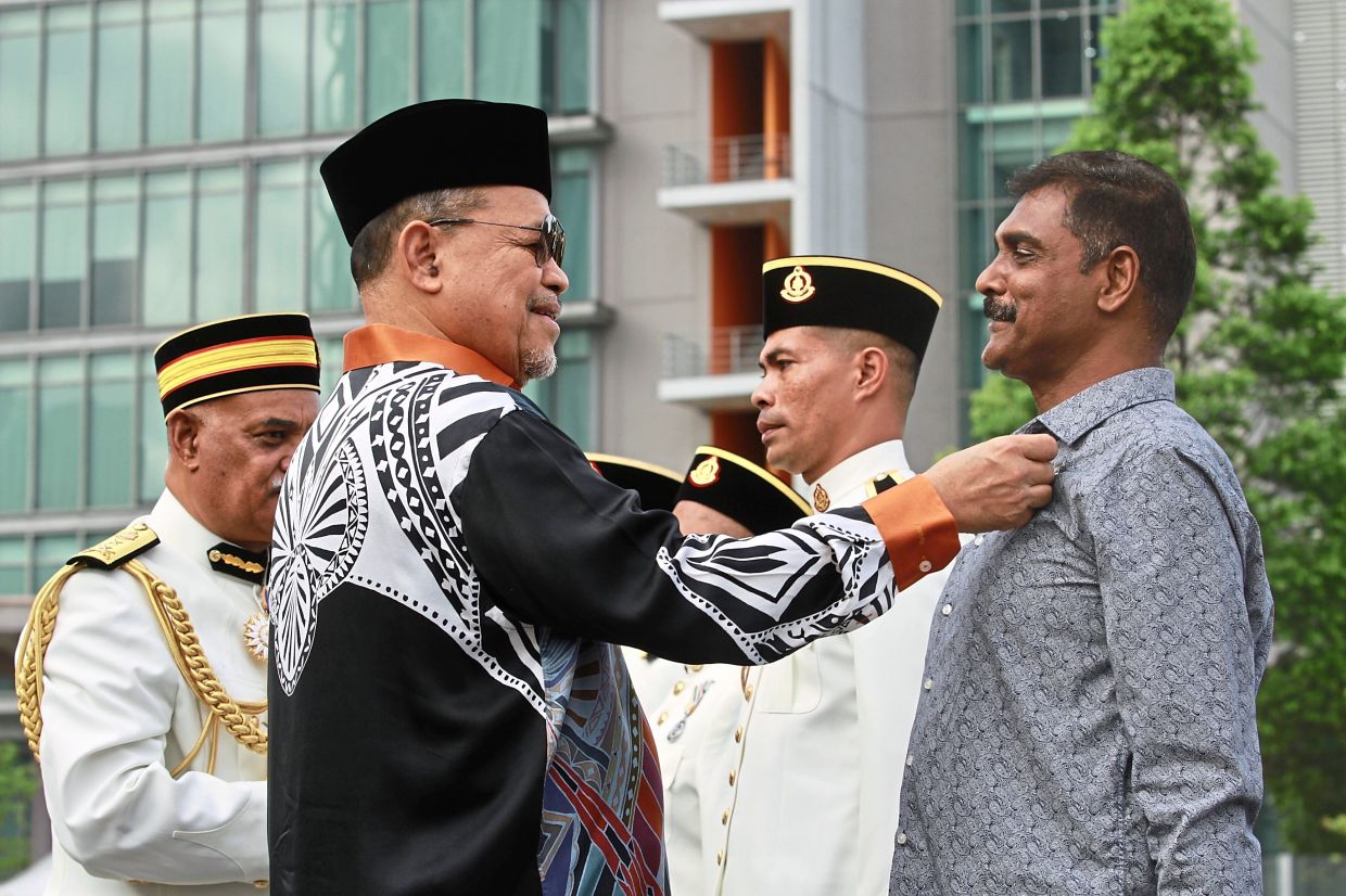 Shahidan pinning a badge of commendation on a DBKL employee during the 53rd Enforcement Day celebration in Cheras, Kuala Lumpur. — Photos: LOW LAY PHON/The Star