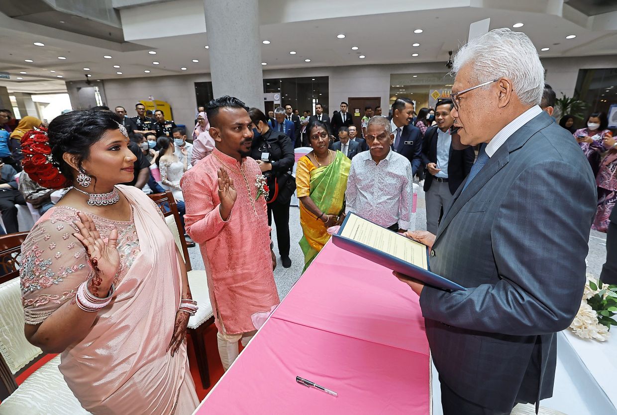 Saying ‘I do’: Hamzah (right) witnessing a civil marriage registration ceremony at the NRD headquarters in Putrajaya. — Bernama