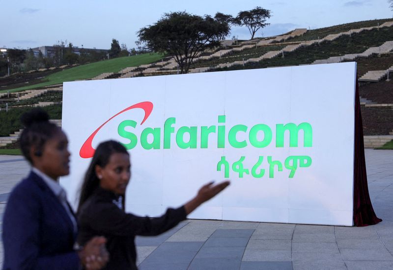 FILE PHOTO Safaricom Ethiopia employees walk past a billboard during the Safaricom ceremony to officially launch its operations in Ethiopia in Addis Ababa Ethiopia October 6 2022. REUTERSTiksa Negeri