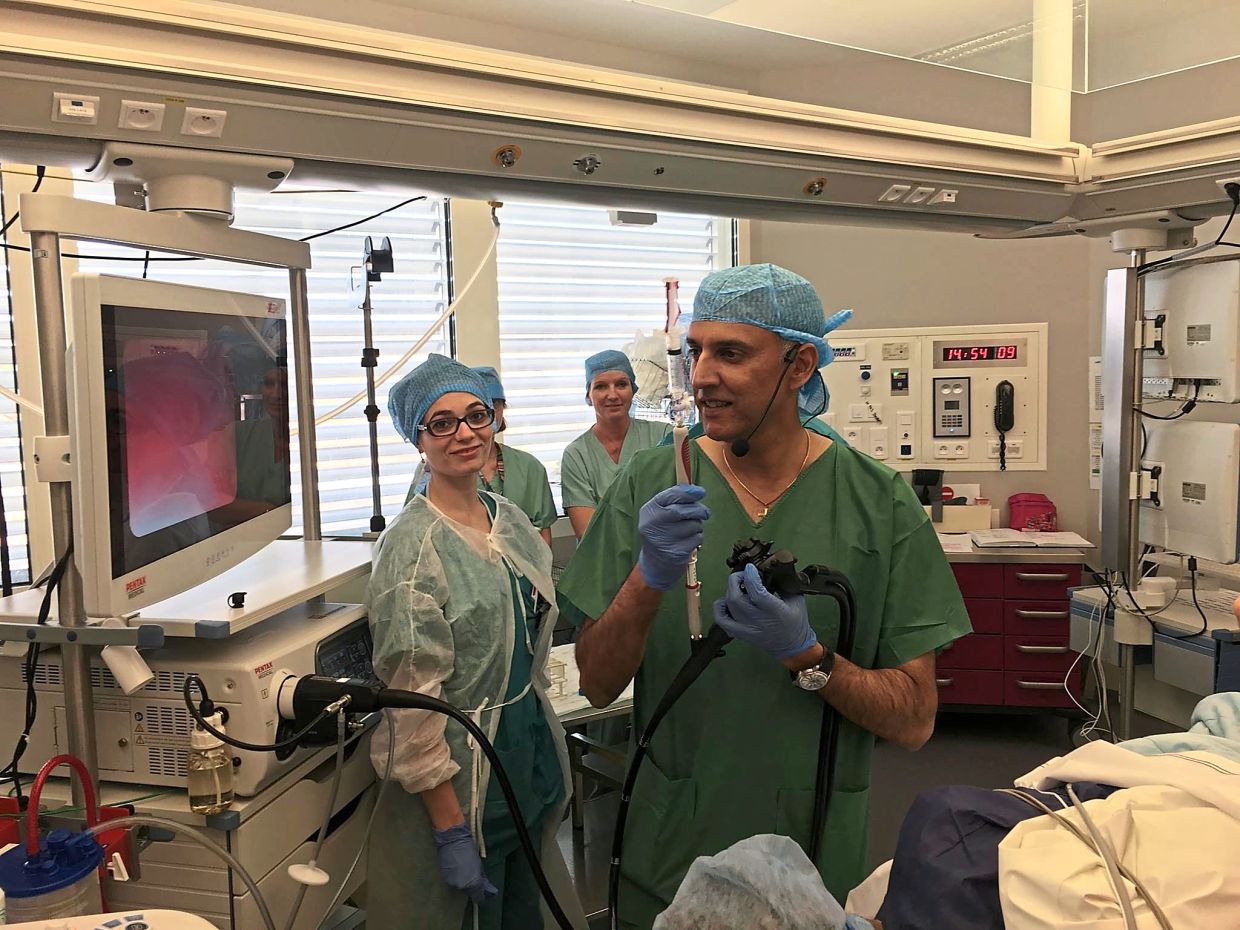 Prior to his illness, Dr Ryan travelled extensively for work; here he is (right) in Marseilles, France, giving a live endoscopy workshop.