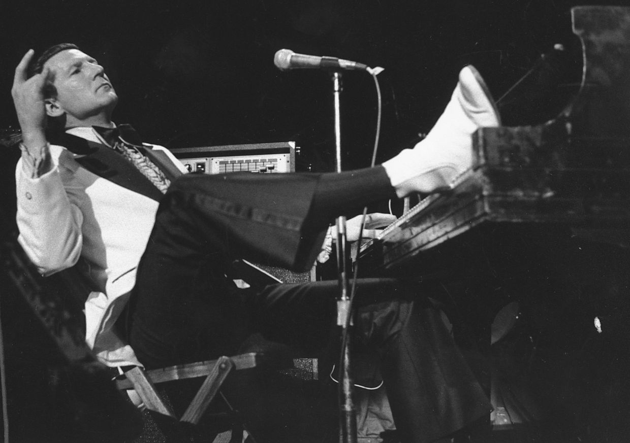 Jerry Lee Lewis props his foot on the piano as he lays back and acknowledges the applause of fans during the fifth annual Rock 'n' Roll Revival at New York's Madison Square Garden on March 14, 1975. S– Photo: AP