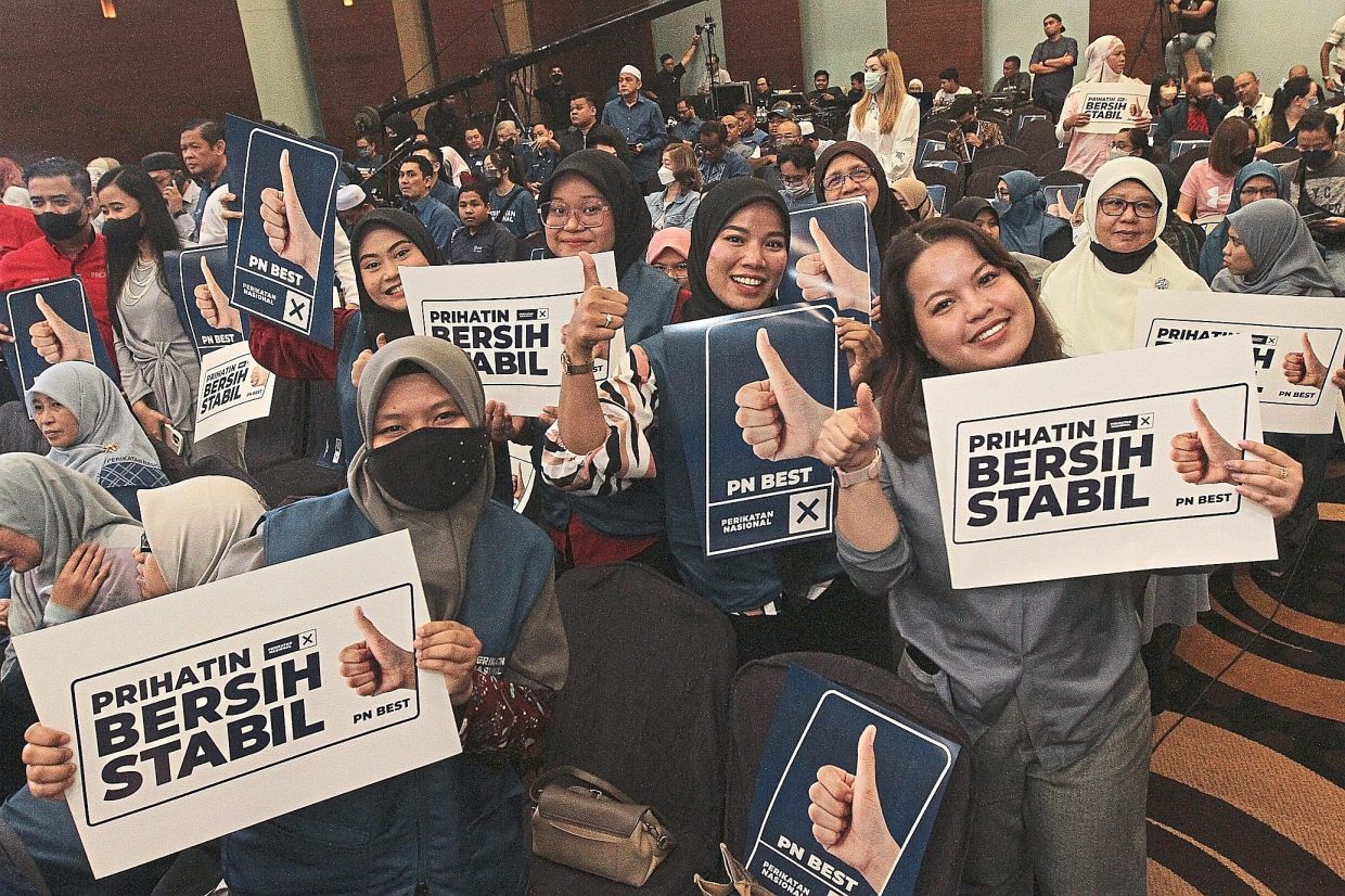 All in favour: Supporters holding up posters carrying the tagline of the theme for Perikatan’s election manifesto during its unveiling by Muhyiddin. — SHAARI CHEMAT /The Star