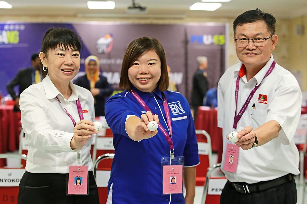 P049 Tanjong candidates (from left) Lim Hui Ying (Pakatan), Tan Kim Nee (Barisan) and H’ng Khoon Leng (Perikatan) showing their ballot number during the nomination day at Dewan Sri Pinang  — CHAN BOON KAI/The Star