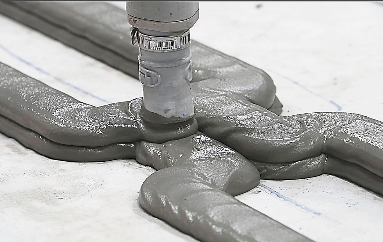 A robotic arm extruding mortar while 3D printing an eventual wall, as part of a two-bedroom, 93sq m house in Detroit. 