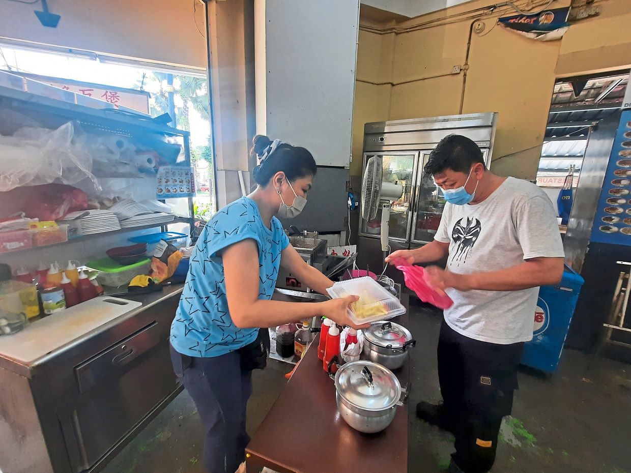 Restaurant owner Wong (right) in Kampung Baru Ampang wants the next Ampang MP to resolve water disruption issues plaguing residents and business owners. — AIDA AHMAD/The Star