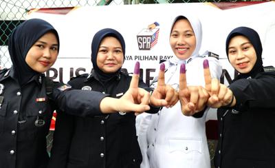 Police personnel showing their inked fingers after casting their early votes at South Klang Police Headquarters in Klang. — KK SHAM/The Star