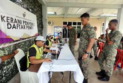 Armed Forces lining up to check their names with Election Commission workers  before they were allowed to go into the hall  to cast their early votes at Kem Bentong, Pahang. — ART CHEN/The Star