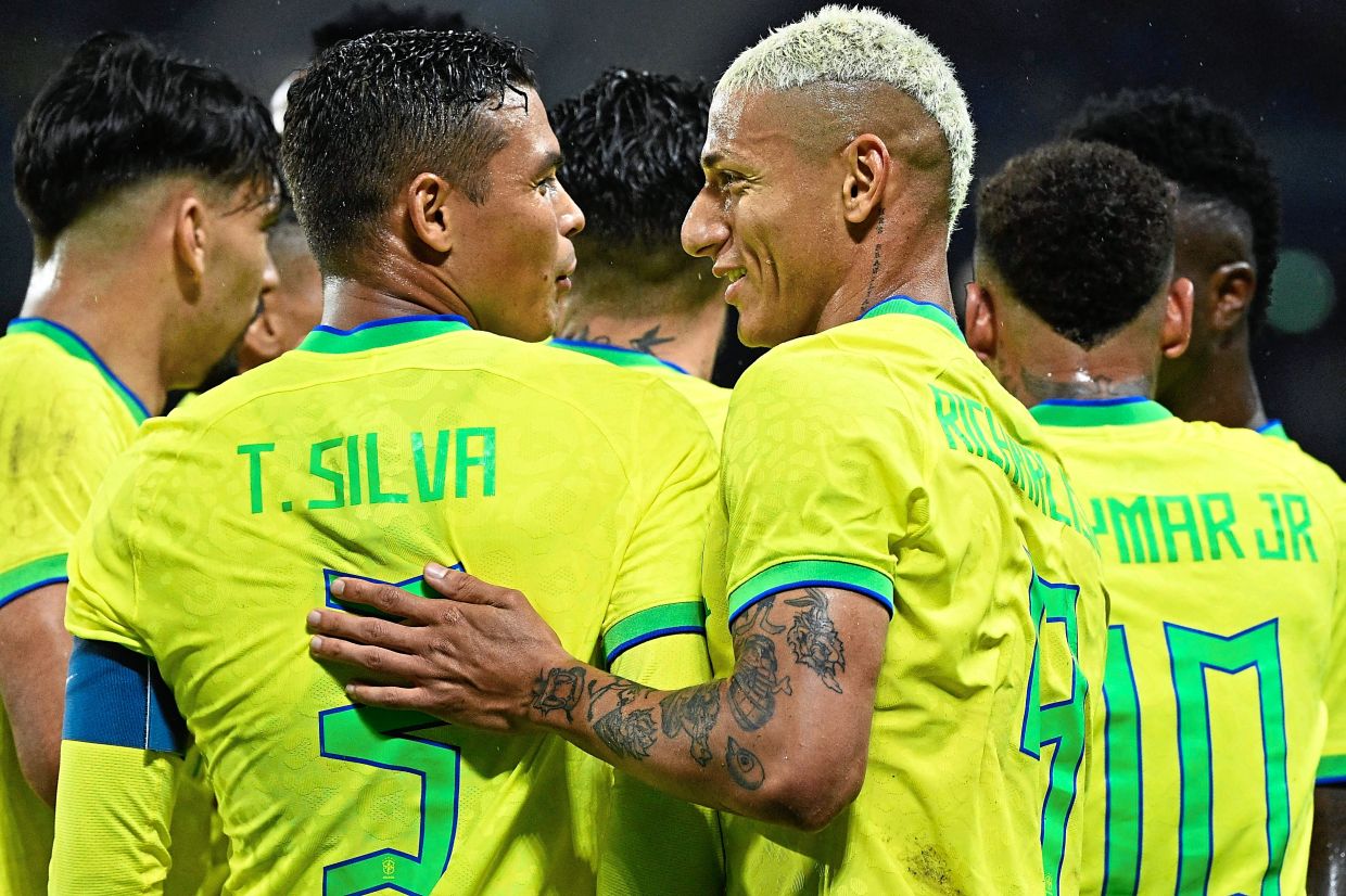 Brazil’s Richarlison (right) with defender Thiago Silva on international duty. They will be chasing a sixth World Cup title in Qatar. – AFP