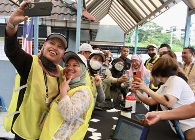 GE15 workers and volunteers taking a selfie with PH candidate  Datuk Seri Dr. Wan Azizah at SK Seri Anggerik. — LOW LAY PHON/The Star