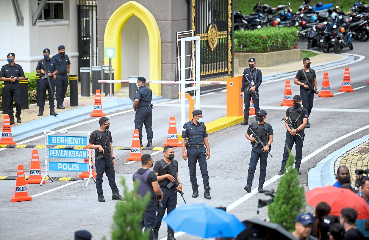 Tight security: Police officers monitoring the situation outside Istana Negara. — AZHAR MAHFOF/The Star