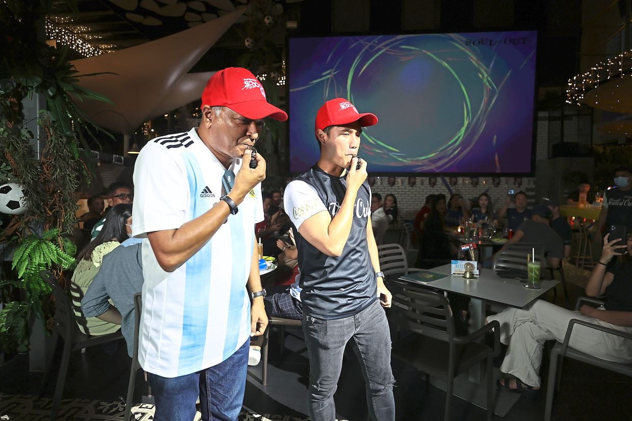 Choo (right) and Brian blowing whistles to mark the start of the World Cup festivities.