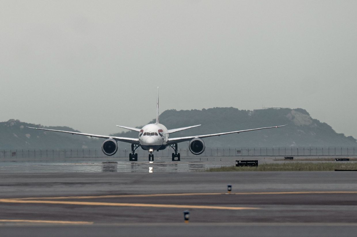 An aircraft operated by British Airways lands on the third runway at Hong Kong International Airport in Hong Kong, China. Hong Kong's new, third runway, which opened in July, is part of a HK$141.5 billion ($18 billion) project that will increase its footprint by 50%, adding 650 hectares (1,606 acres), equivalent to the size of Gibraltar. - Bloomberg