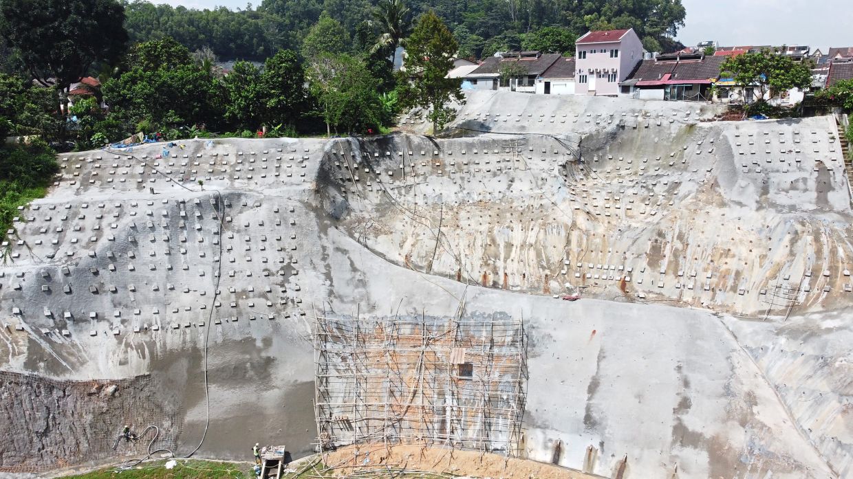 The Malaysian Institute of Public Works personnel helping to rehabilitate landslides at  Taman Mega Jaya in Ampang, including shoring the areas with concrete. — IZZRAFIQ ALIAS/The Star