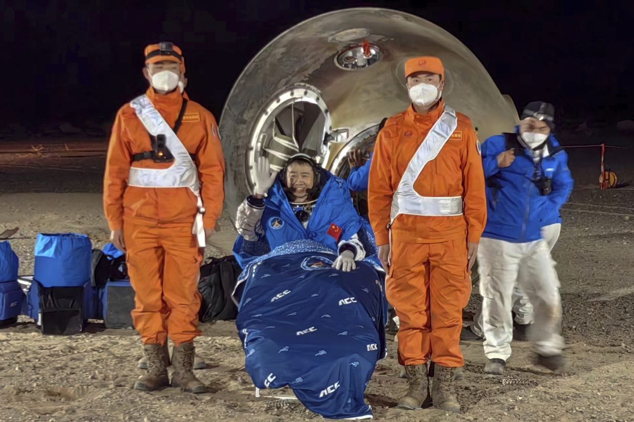 In this photo released by Xinhua News Agency, astronaut Chen Dong waves as he sits outside the re-entry capsule of the Shenzhou-14 manned space mission after it lands successfully at the Dongfeng landing site in northern China's Inner Mongolia Autonomous Region, Sunday night, Dec. 4, 2022. Three Chinese astronauts landed in a northern desert on Sunday after six months working to complete construction of the Tiangong station, a symbol of the country's ambitious space program, state TV reported. - AP