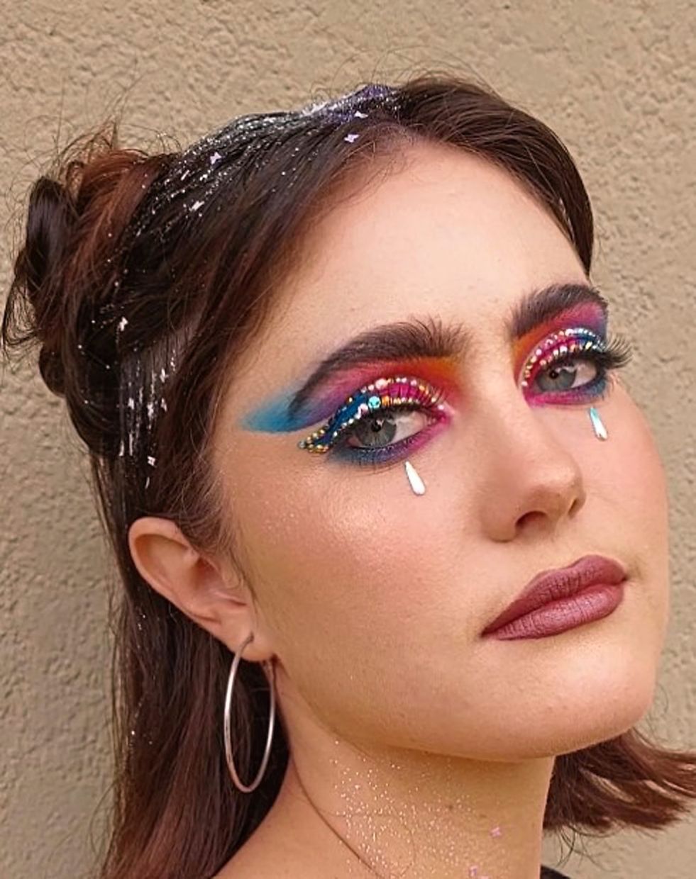 Go all out with bold eyeshadows and sparkly face jewels. Photo: Instagram/Vicky Makeup Artistry